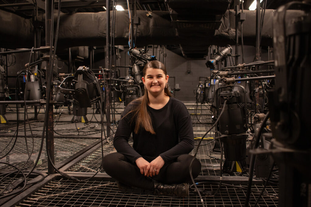 Lindsey sitting in the light grid above the theater